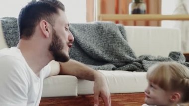 Mutlu baba ve onun yerde birlikte zaman geçirmesi. Küçük tatlı kız babasını öpüyor.