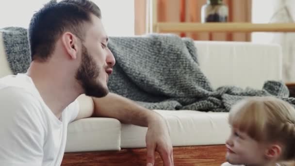 Glücklicher Vater und seine gemeinsame Zeit auf dem Fußboden. Kleines süßes Mädchen küsst ihren Vater — Stockvideo