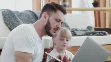Mutlu baba, küçük kızıyla vakit geçiriyor. Deftere bakıyorlar.