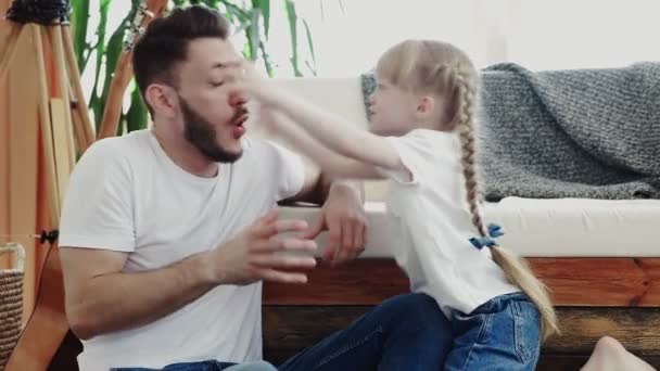 Kleines Mädchen spielt mit ihrem Vater. Sie macht beängstigende und lustige Posen — Stockvideo