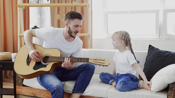 Jovem pai e filha família feliz passar o tempo juntos, tocando guitarra na sala de estar calor casa fundo . — Fotografia de Stock