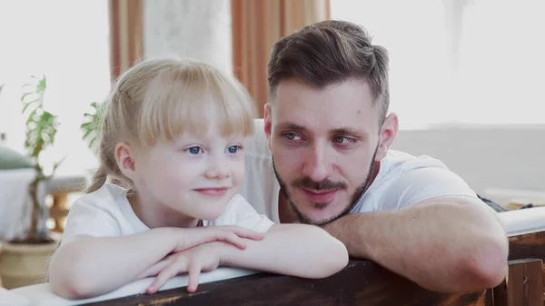 Güzel kızına bakan yakışıklı bir babanın portresi.