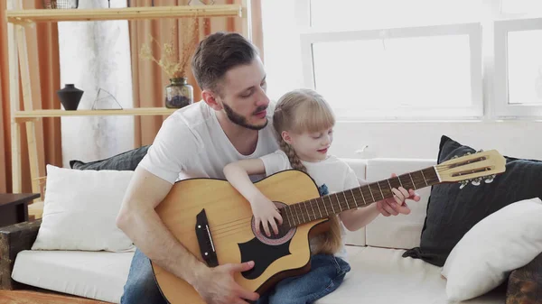 Jovem pai e filha família feliz passar o tempo juntos, tocando guitarra na sala de estar calor casa fundo . — Fotografia de Stock