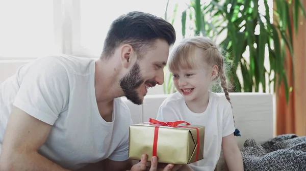 Liten söt flicka ger födelsedagspresent till sin far för födelsedag eller pappa dag. — Stockfoto