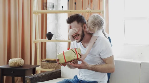 Söt dotter ger present till sin förvånade far. Begreppet överraskning presentförpackning för födelsedag eller pappa dag. — Stockfoto