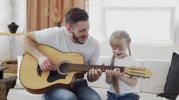Jovem pai e filha família feliz passar o tempo juntos, tocando guitarra na sala de estar calor casa fundo . — Fotografia de Stock