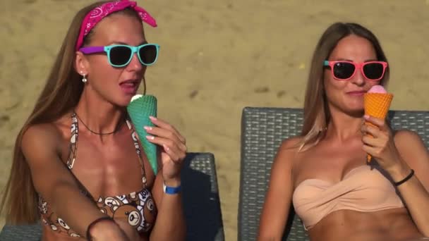 Twee meisjes die ijs eten op het strand — Stockvideo