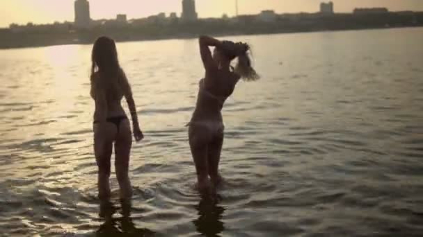 Vrouwen wandelen en zwemmen in het water — Stockvideo