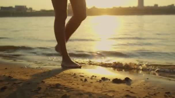 Vrouw die op blote voeten op het strand loopt — Stockvideo
