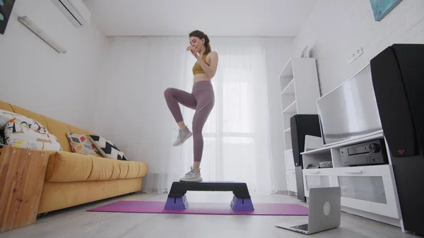 İnternetteki kadın eğitmeninin yardımıyla internet hizmetlerini kullanıyor. Bir kadın platforma basıyor ve bacaklarını kaldırıyor.