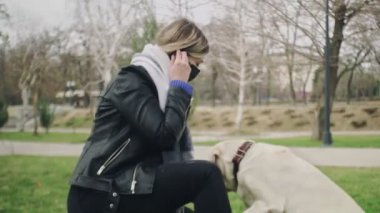 2019-2020 Coronavirus karantinasında karantina Coronavirus COVID-19 salgını sırasında kadın labrador köpeğiyle parkta oynuyor.