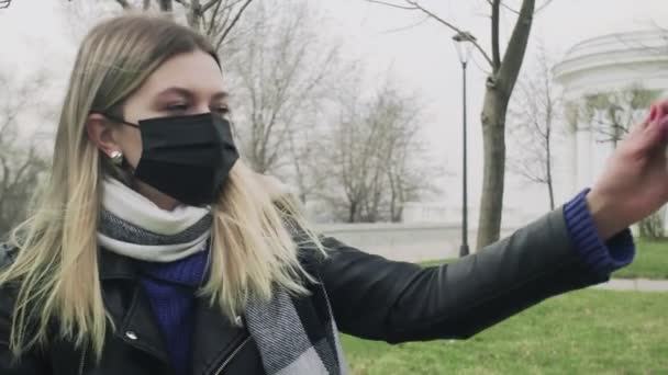 Primer plano de la mujer con máscara negra juega con su perro labrador en el parque durante la pandemia del coronavirus de cuarentena COVID-19 — Vídeo de stock