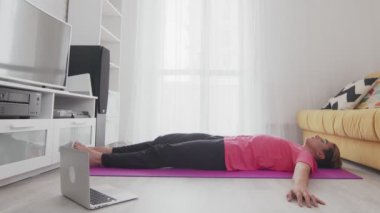 Makyajlı genç transseksüel homoseksüel adam omurga germe egzersizleri yapıyor.