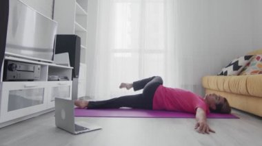 Makyajlı genç transseksüel homoseksüel adam omurga germe egzersizleri yapıyor.