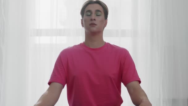 Young transgender homosexual man with makeup doing yoga breath exercise — Stock Video