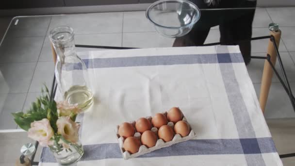 Chef profissional está cozinhando bolo. Vista superior da mesa com ovos, batedor e peneira. Mulher se prepara para cozinhar — Vídeo de Stock