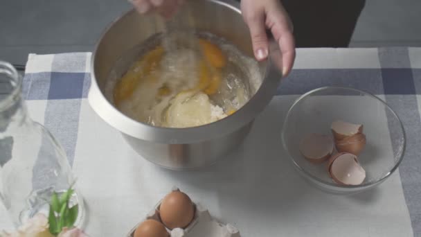 Professionell kock lagar tårta. Ung attraktiv hemmafru använder visp för att blanda socker, ägg och olja i metallskål — Stockvideo