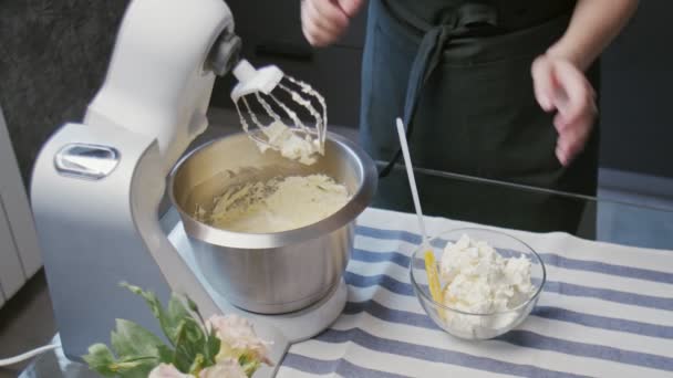 El chef profesional está cocinando pastel. Joven ama de casa atractiva pone crema blanca en mezclador profesional — Vídeos de Stock