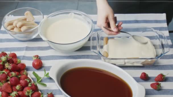 El chef profesional está cocinando pastel de tiramisú. Joven ama de casa atractiva vierte crema blanca en tiramisú — Vídeos de Stock