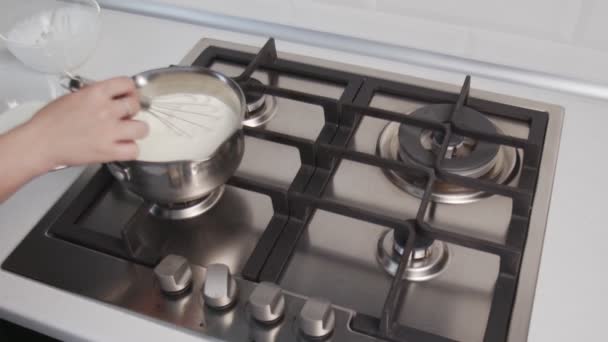 Le chef cuisinier cuisine des gâteaux. Main de femme méconnaissable cuisine sauce à la crème chaude dans une casserole debout sur le poêle à gaz — Video