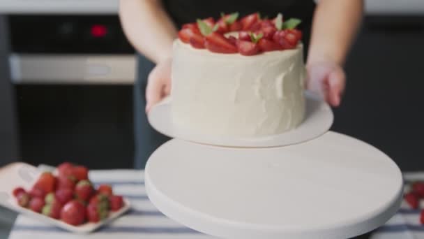 Chef profissional está cozinhando bolo. Close up de belo bolo branco com morango no topo em uma cozinha moderna — Vídeo de Stock