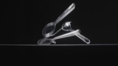 Transperent çay kaşığı siyah arkaplan yavaş çekim videosuna düşer.