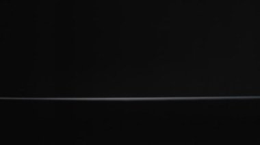 Beyaz çay kaşığı siyah arka plan yavaş çekim videosuna düşer.