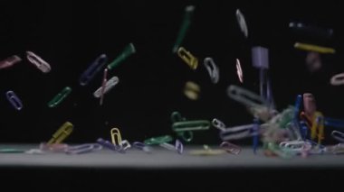 Renkli Kağıt Kıskaçları siyah arkaplan yavaş çekim videosuna düşer.