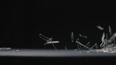 Kağıt Kıskaç siyah arkaplan yavaş çekim video üzerine düşer.