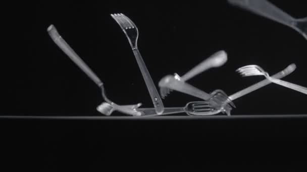 Transperent forks falls on black background slow motion video. — Stock Video