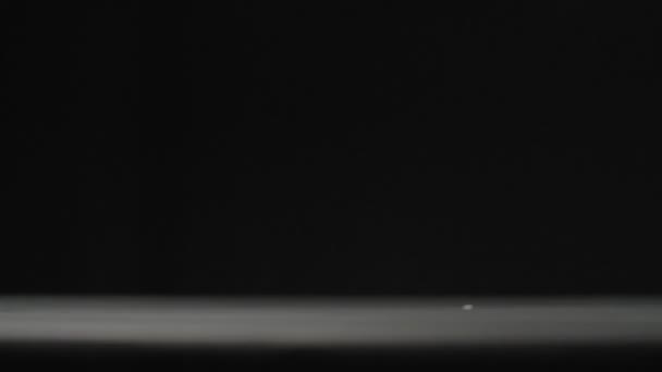 プラスチックカップは黒の背景スローモーションビデオに落ちる. — ストック動画