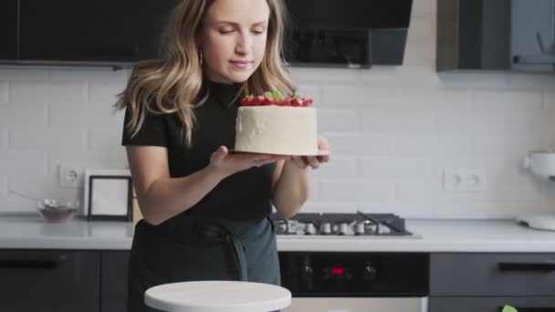 Blog de confitería. Mujer de camisa negra fotografiando pastel decorado con fresa . — Vídeos de Stock