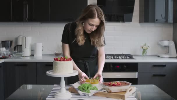 Profesyonel şef kek pişiriyor. Çilekli güzel beyaz pasta, Panna Cotta ve masada tiramisu keki. — Stok video