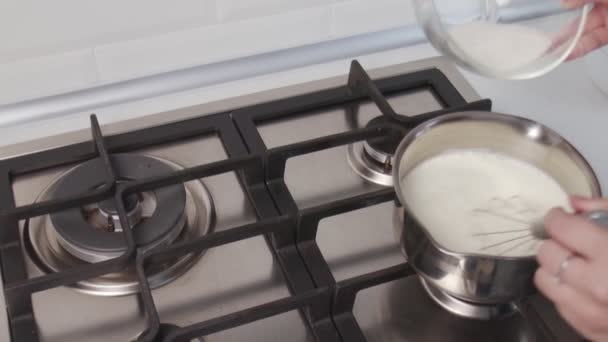 El chef profesional está cocinando pastel. Mano de mujer irreconocible cocinando salsa de crema caliente en cacerola de pie sobre estufa de gas — Vídeos de Stock