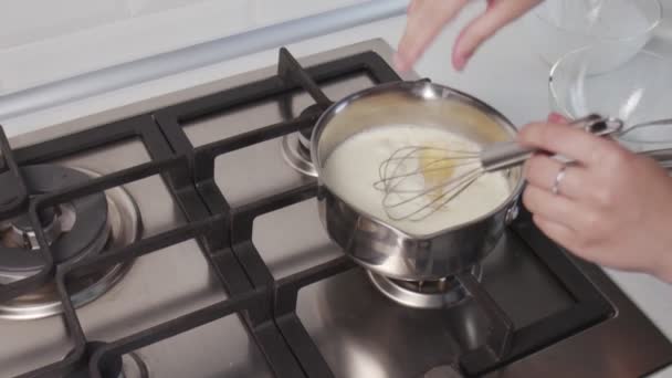 El chef profesional está cocinando pastel. Mano de mujer irreconocible cocinando salsa de crema caliente en cacerola de pie sobre estufa de gas — Vídeo de stock