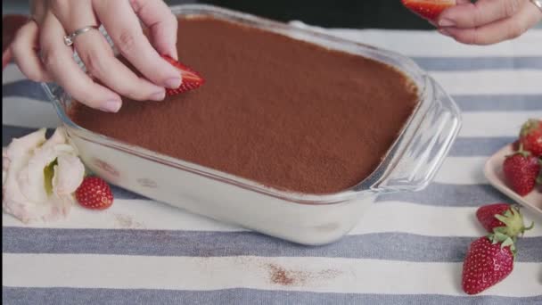 Profi-Koch kocht Tiramisu-Kuchen. Großaufnahme einer Frau legt Erdbeere auf einen schönen Tiramisu-Kuchen — Stockvideo