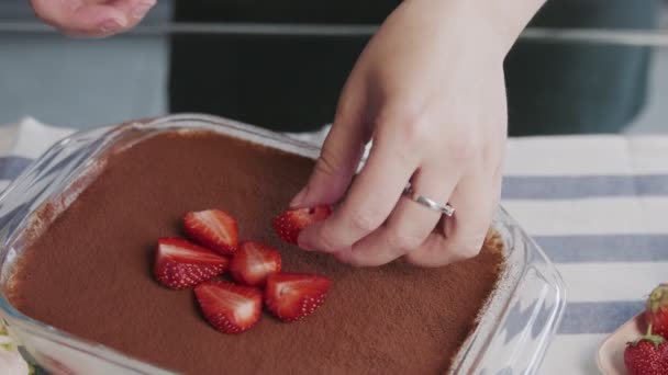 Profi-Koch kocht Tiramisu-Kuchen. Großaufnahme einer Frau legt Erdbeere auf einen schönen Tiramisu-Kuchen — Stockvideo