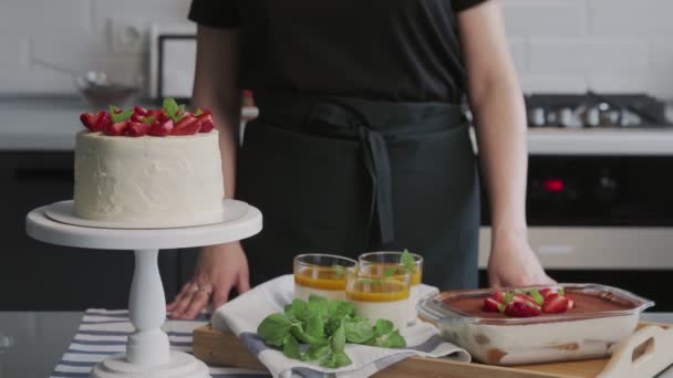Professionell kock lagar tårta. Närbild av vacker vit kaka med jordgubbe, Panna Cotta och tiramisu kaka — Stockvideo