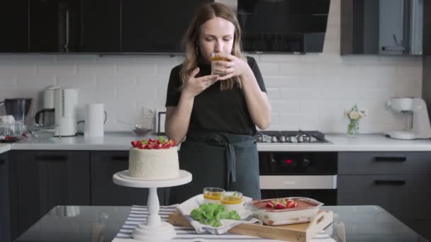 Profesyonel şef kek pişiriyor. Çilekli güzel beyaz pasta, Panna Cotta ve masada tiramisu keki. — Stok video