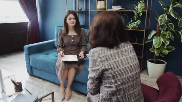 Ung kvinna fyller psykologi prov på en rådgivning session med psykoterapeut — Stockvideo