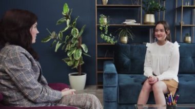 Gülümseyen genç kız, kontrol terapisi danışmanlığında genç bir hastayla konuşan kadın doktor çocuk doktoru psikologları dinliyor.
