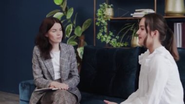 Çocuk problemleri. Bir çocuk kanepede oturur ve bir doktorla konuşur. Kadın kağıda gençlik kelimeleri yazıyor..