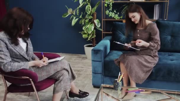 Mujer joven haciendo la prueba de dibujo en una sesión de consejería con psicoterapeuta — Vídeo de stock
