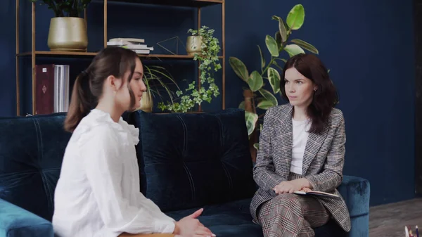 Çocuk problemleri. Bir çocuk kanepede oturur ve bir doktorla konuşur. Kadın kağıda gençlik kelimeleri yazıyor..