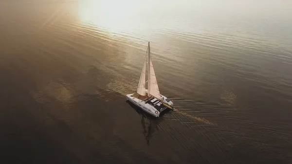 Aerial view of fisherman sailing on a sailing yacht. Sunset