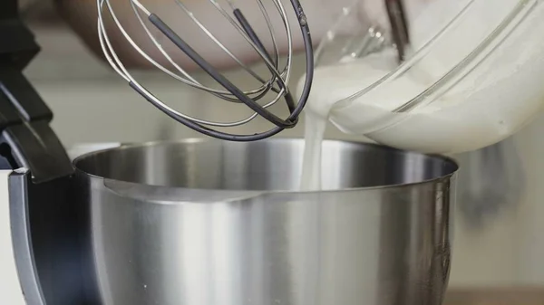 Electric mixer being used to mix cream and dough — Stock Photo, Image