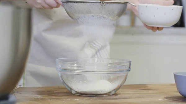 Womans hands sifting flour on a table. Cooking and backing preparation. — Stock Photo, Image