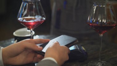 NFC teknolojisiyle ödeme yapan bir adam kafede cep telefonundan.