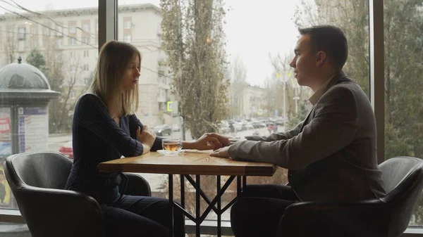 Knappe jongeman met zijn vrouw hebben een date in restaurant — Stockfoto