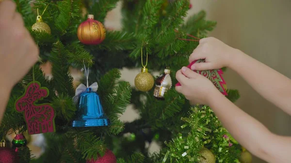 Mère et enfant décorent ensemble le sapin de Noël à la maison — Photo